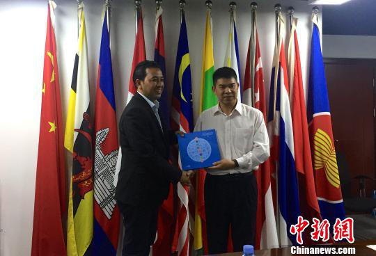 中国—东盟博览会秘书处副秘书长黄平西(右)与柬埔寨新闻部新闻与传播总司副总司长春占皮仑(左)互赠礼物。 中国—东盟博览会秘书处副秘书长黄平西(右)与柬埔寨新闻部新闻与传播总司副总司长春占皮仑(左)互赠礼物。